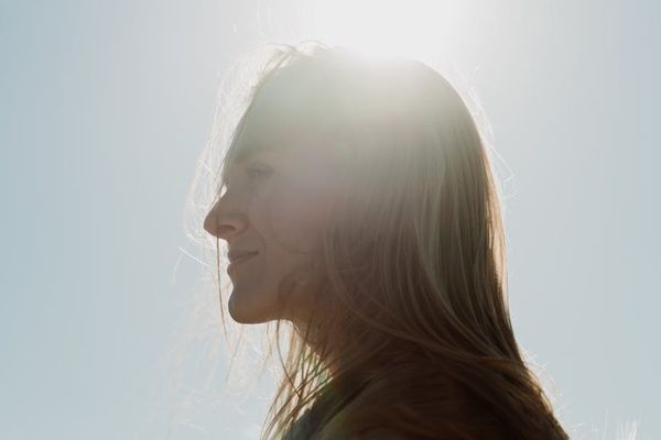 Silhouette of a person breathing deeply at sunrise.
